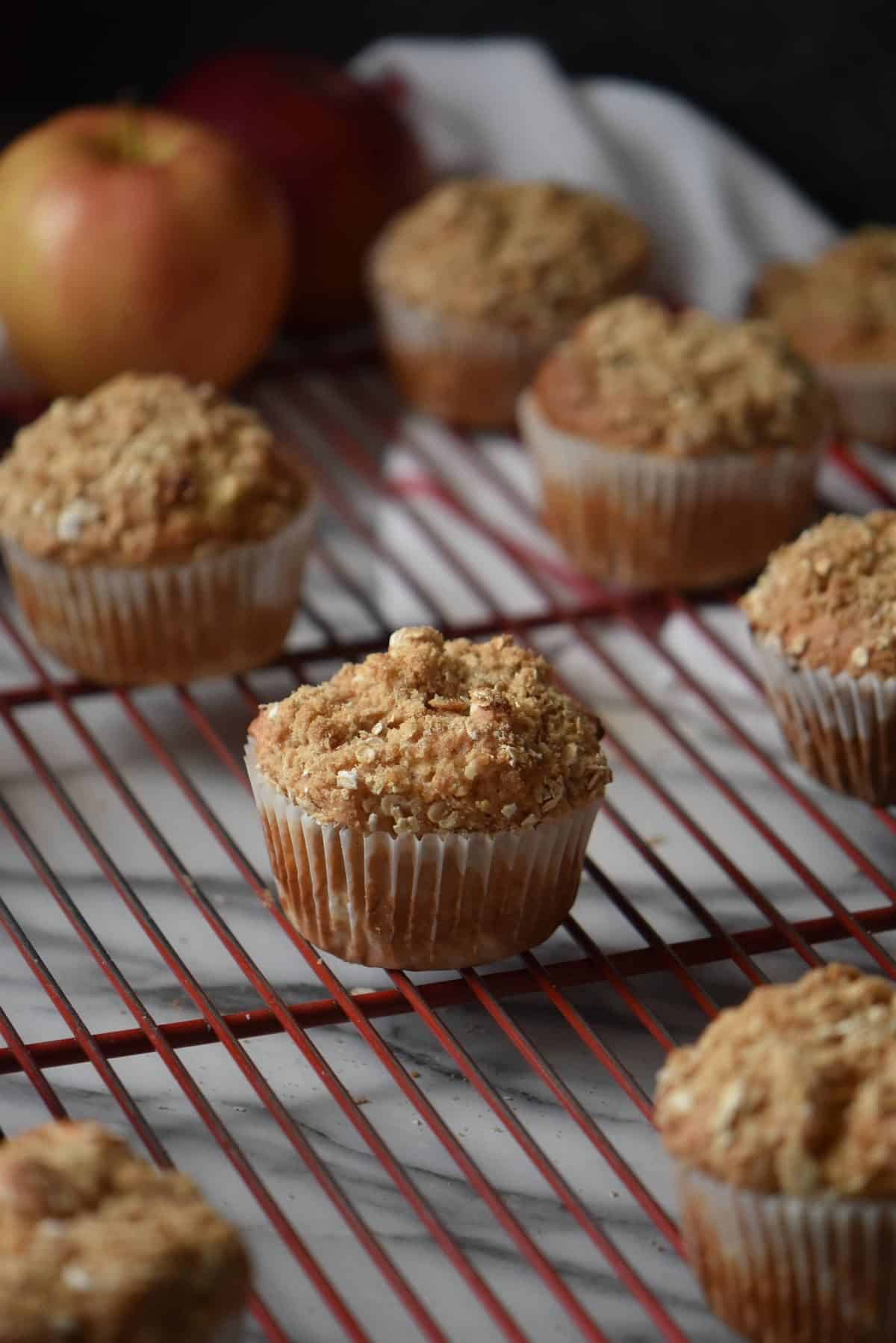 Apple muffins cooling off on a wire rack.