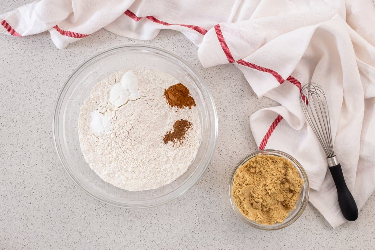 The dry ingredients to make this apple muffins recipe are in two bowls.