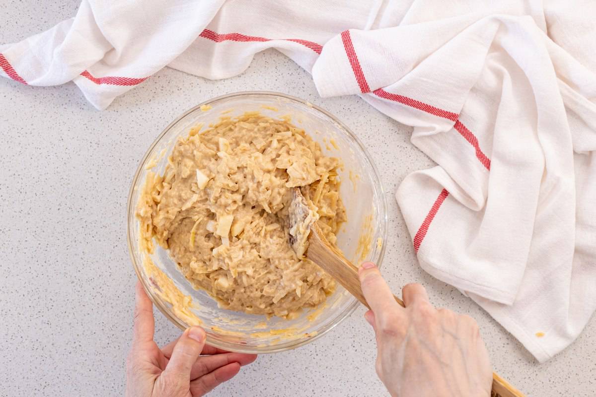 The gentle folding of fresh apples in the apple muffin batter.