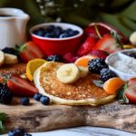 Buttermilk pancakes on a pancake board, surrounded by fruits.