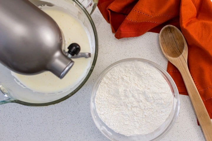 The addition of the dry ingredients to the wet ingredients to make Italian wine cookies.