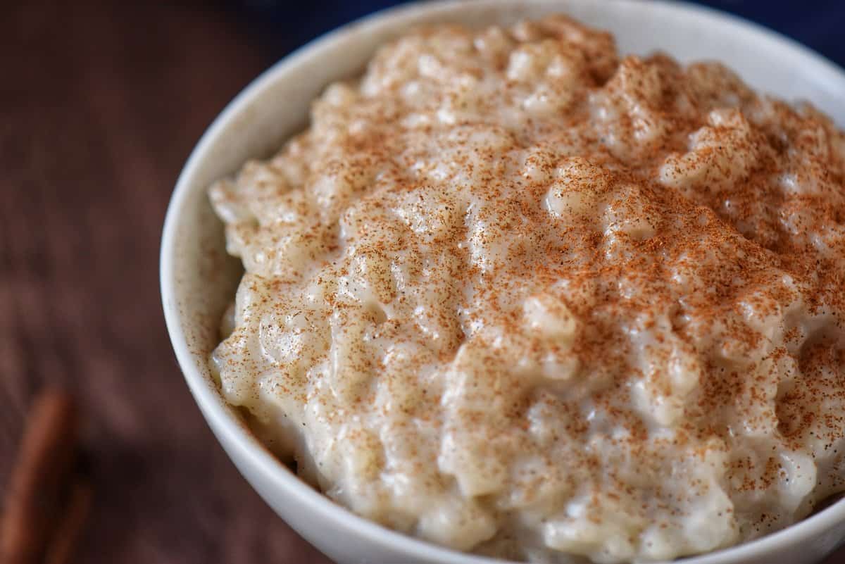 A close up photo of rice pudding sprinkled with ground cinnamon.