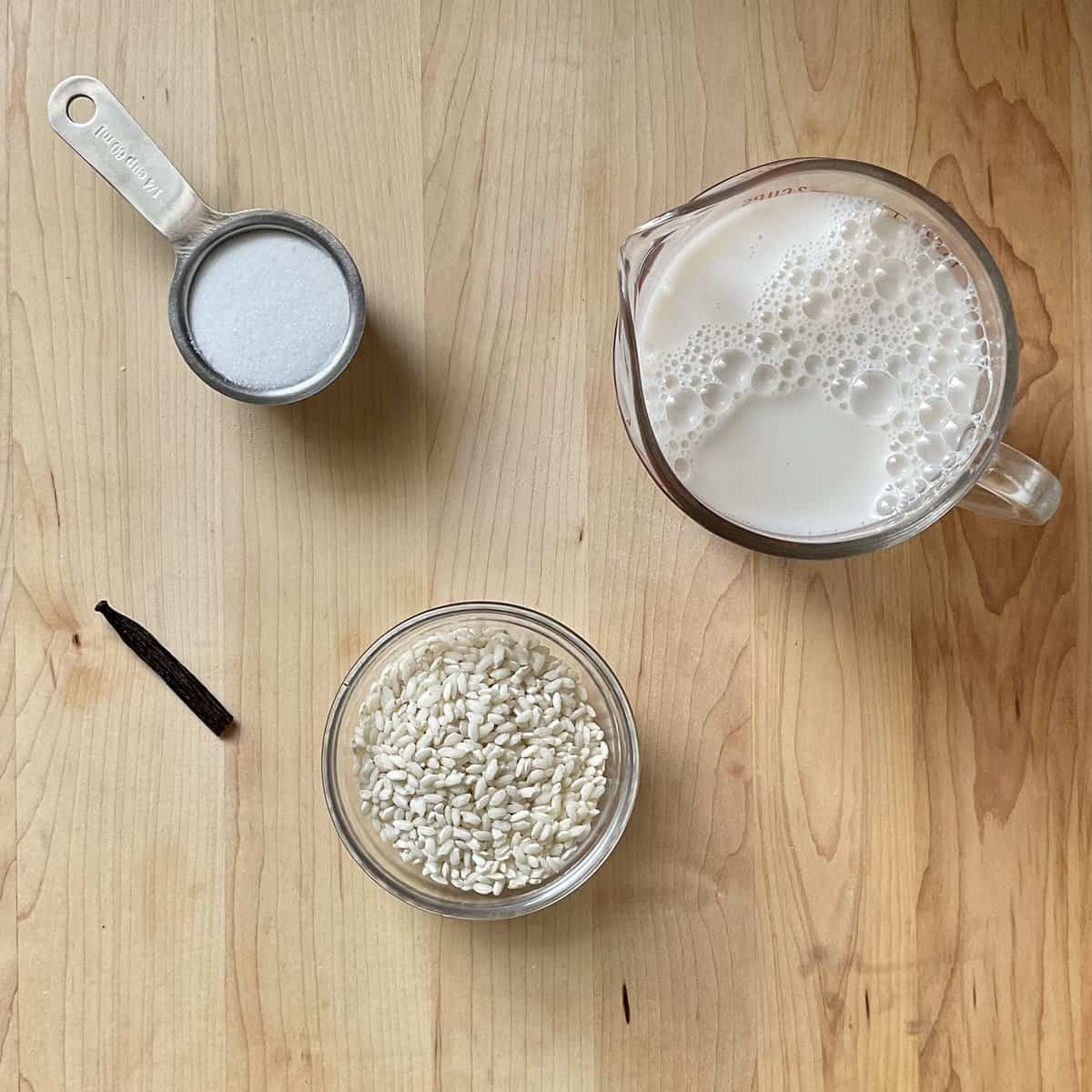 Ingredients to make rice pudding on a wooden board.