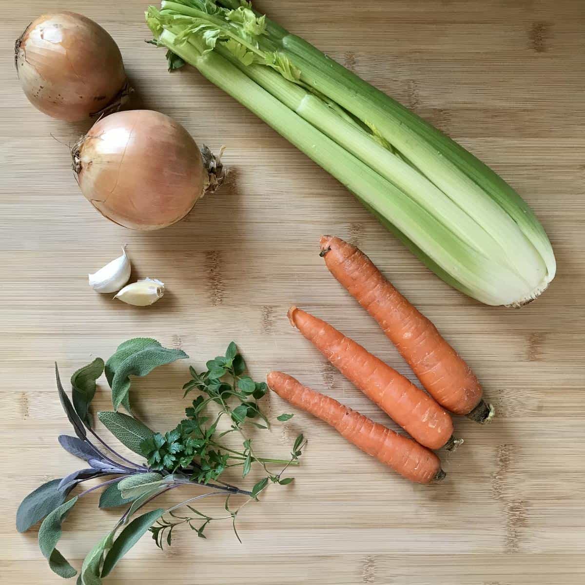 Some of the fresh vegetables to make a bean soup on a wooden board.