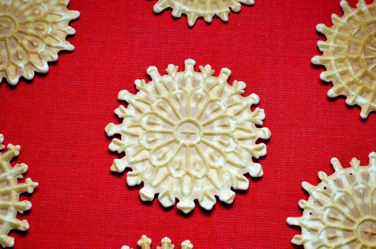 Pizzelle della nonna are shown on a red tablecloth.