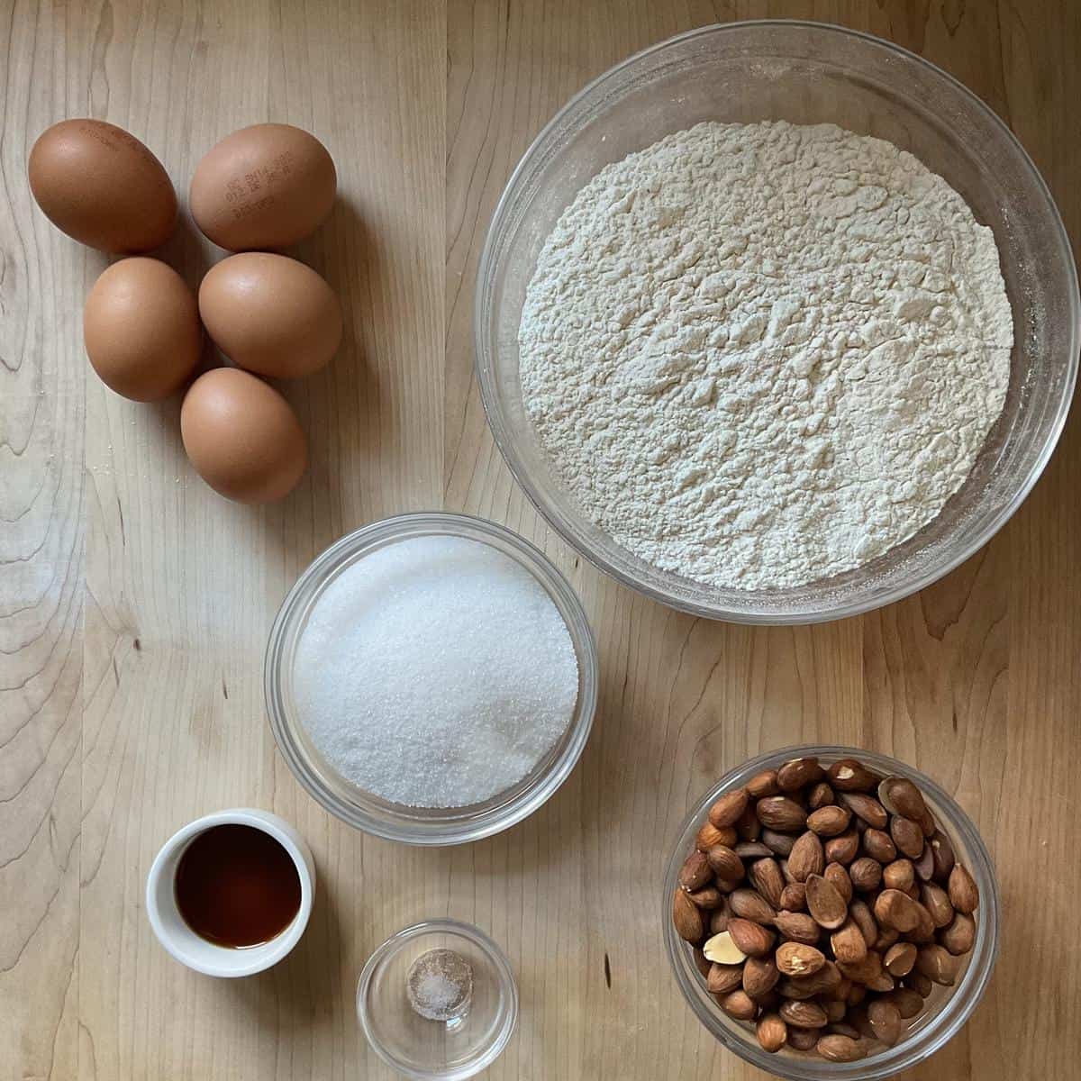 Ingredients to make almond bread biscotti on a wooden board.