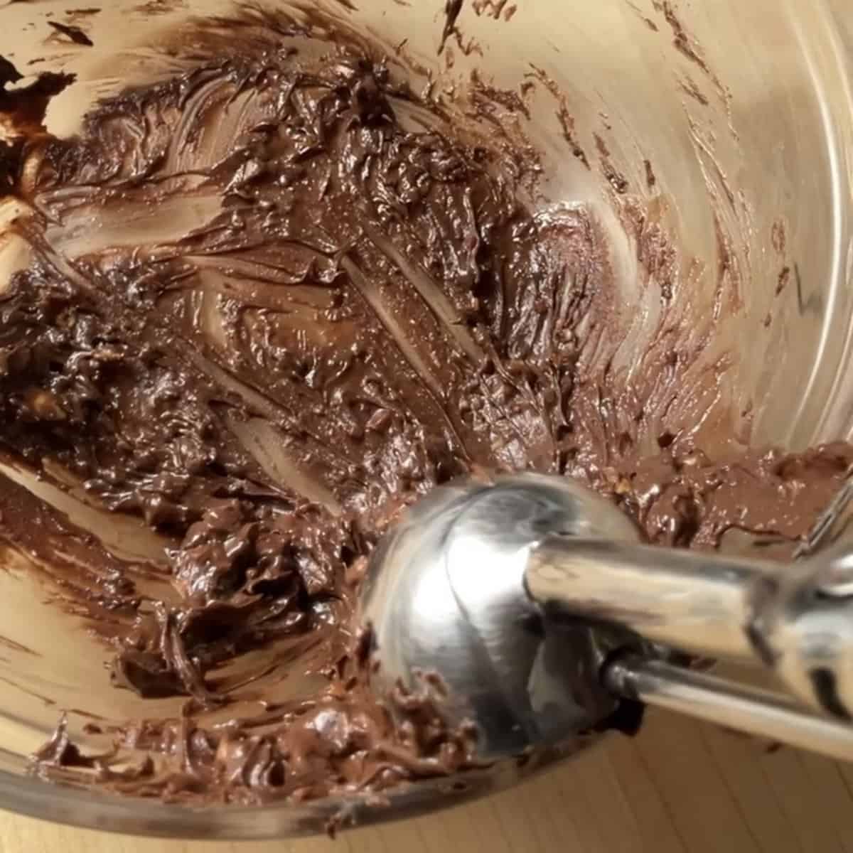 An ice cream scooper portioning the chocolate hazelnut mixture.