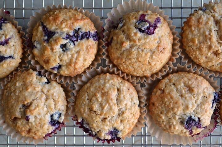 A few blueberry muffins on a cooling rack.