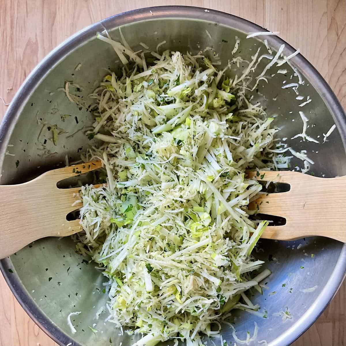 The ingredients to make a celery root salad are tossed together in a mixing bowl.