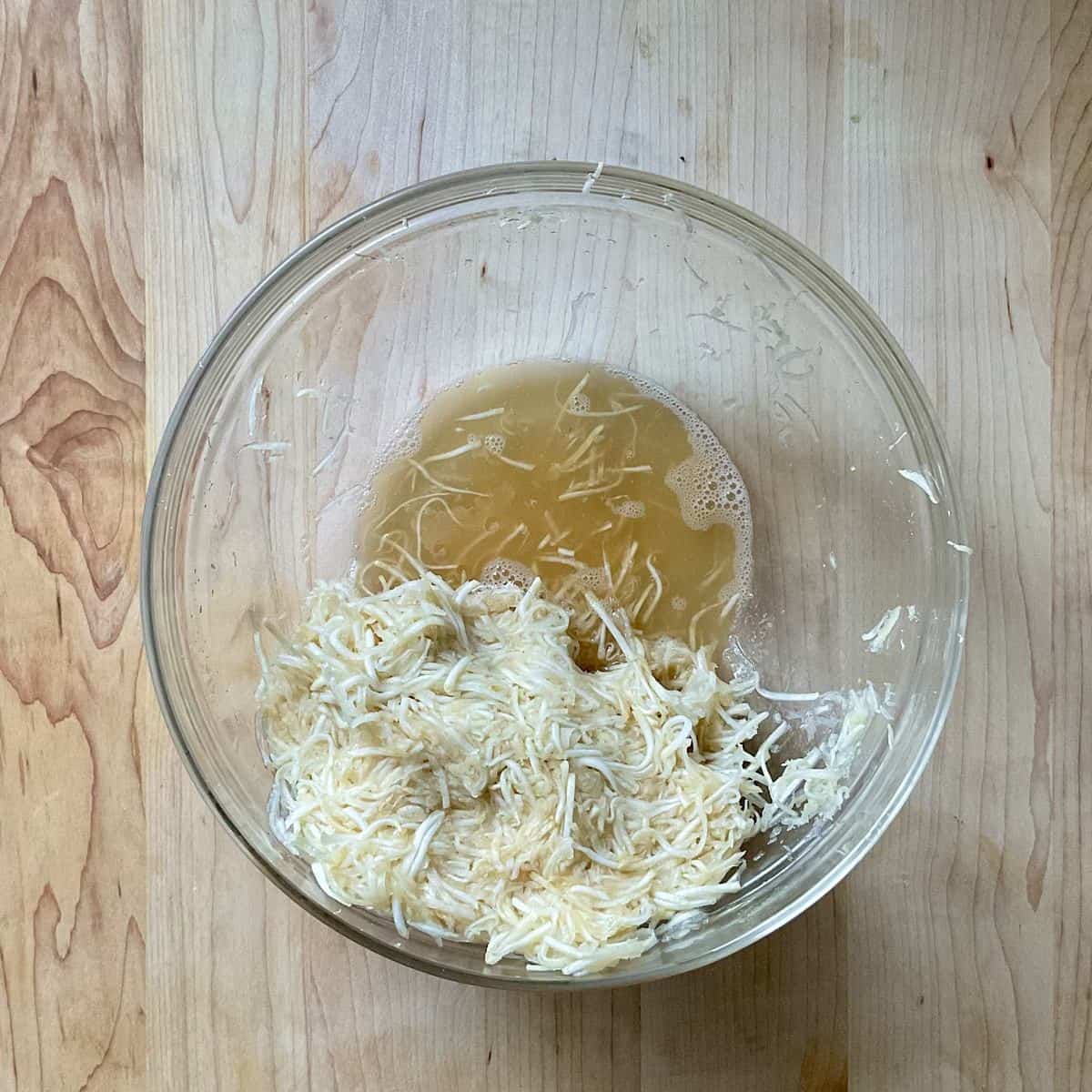 The excess liquid from squeezing celery root in a bowl.