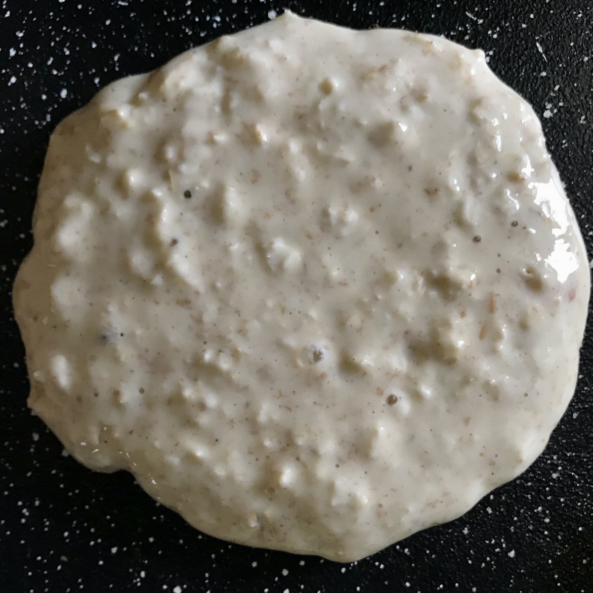 A single pancake on a griddle pan.