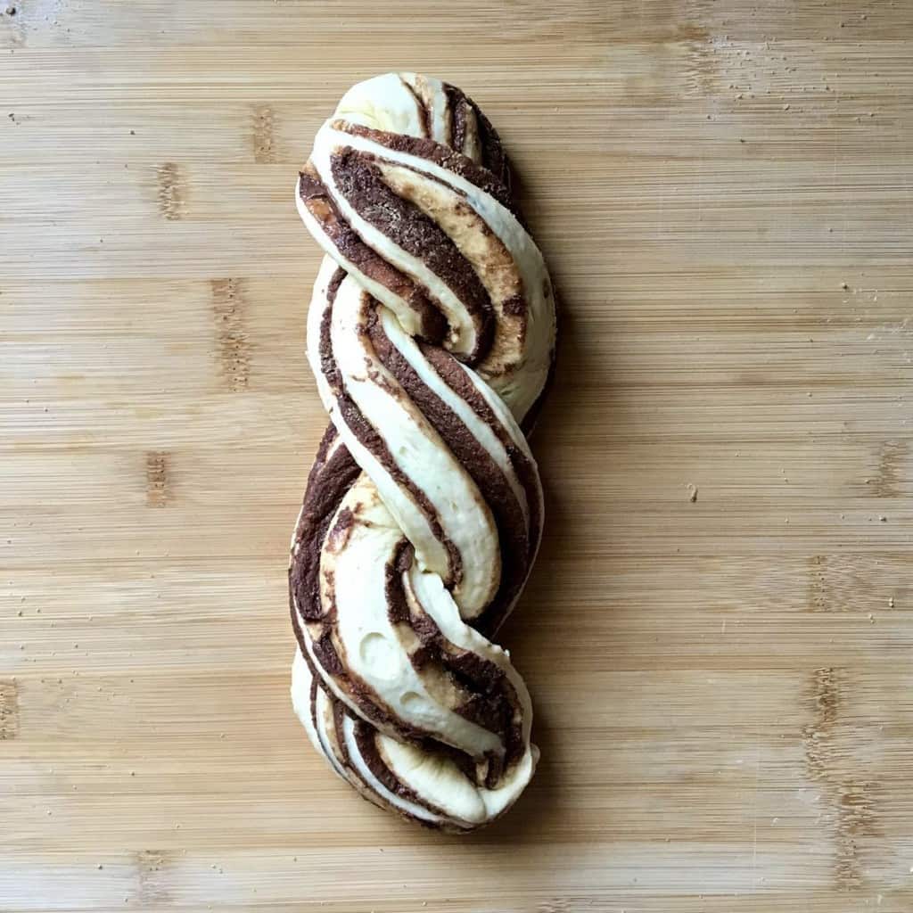 A braided sweet bread on a wooden board.