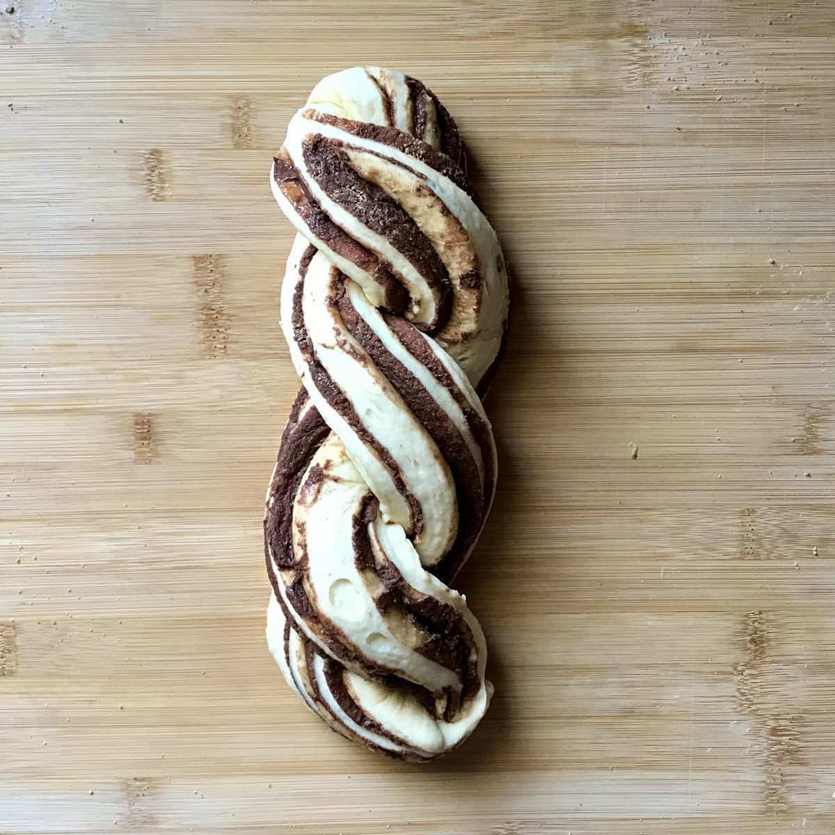 A braided sweet bread on a wooden board. 