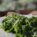 Cooked Italian broccoli rabe on a white plate.