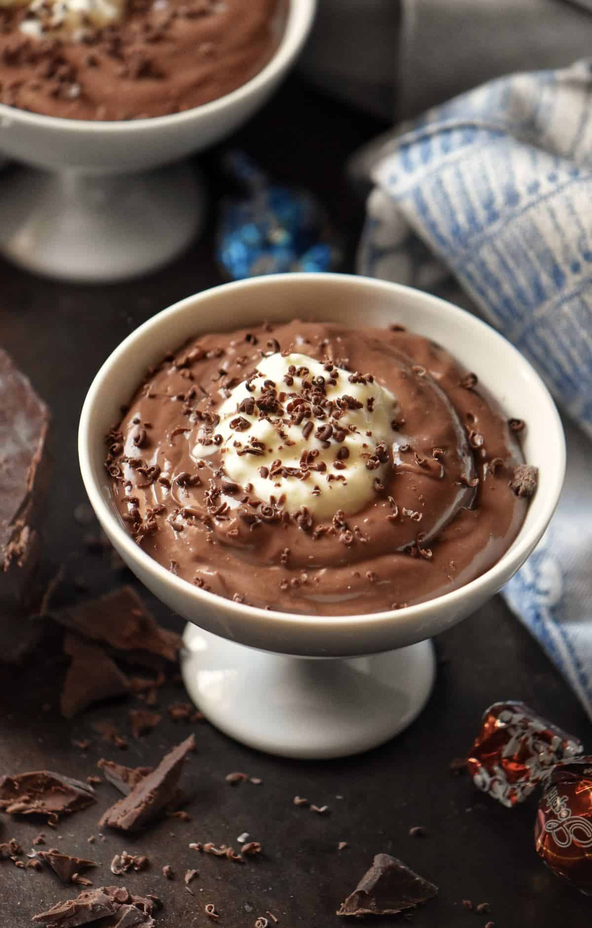 An overhead shot of dark chocolate pudding surrounded by grated chocolate.