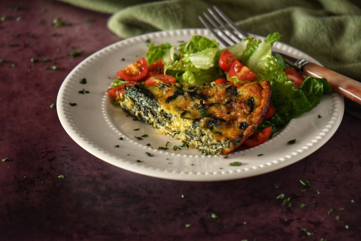 A slice of the spinach quiche on a plate.