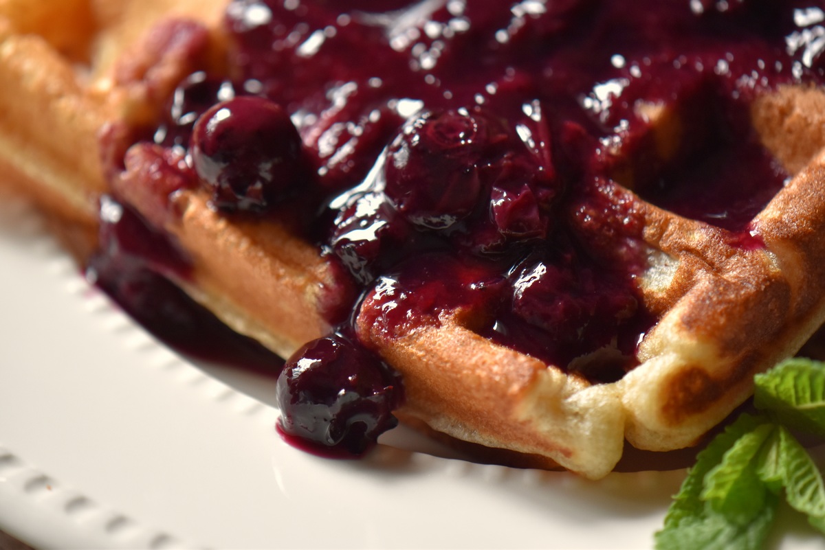 Waffles topped with blueberry sauce.