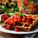 Macerated strawberries on waffles.
