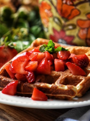 Macerated strawberries on waffles.