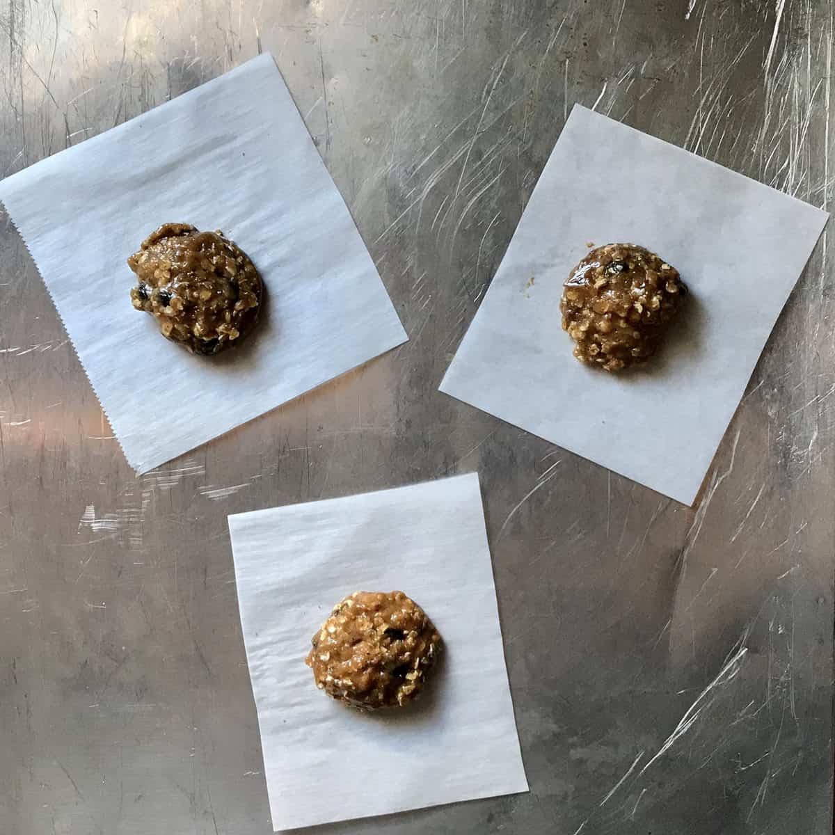 Balls of cookie dough on parchment paper. 