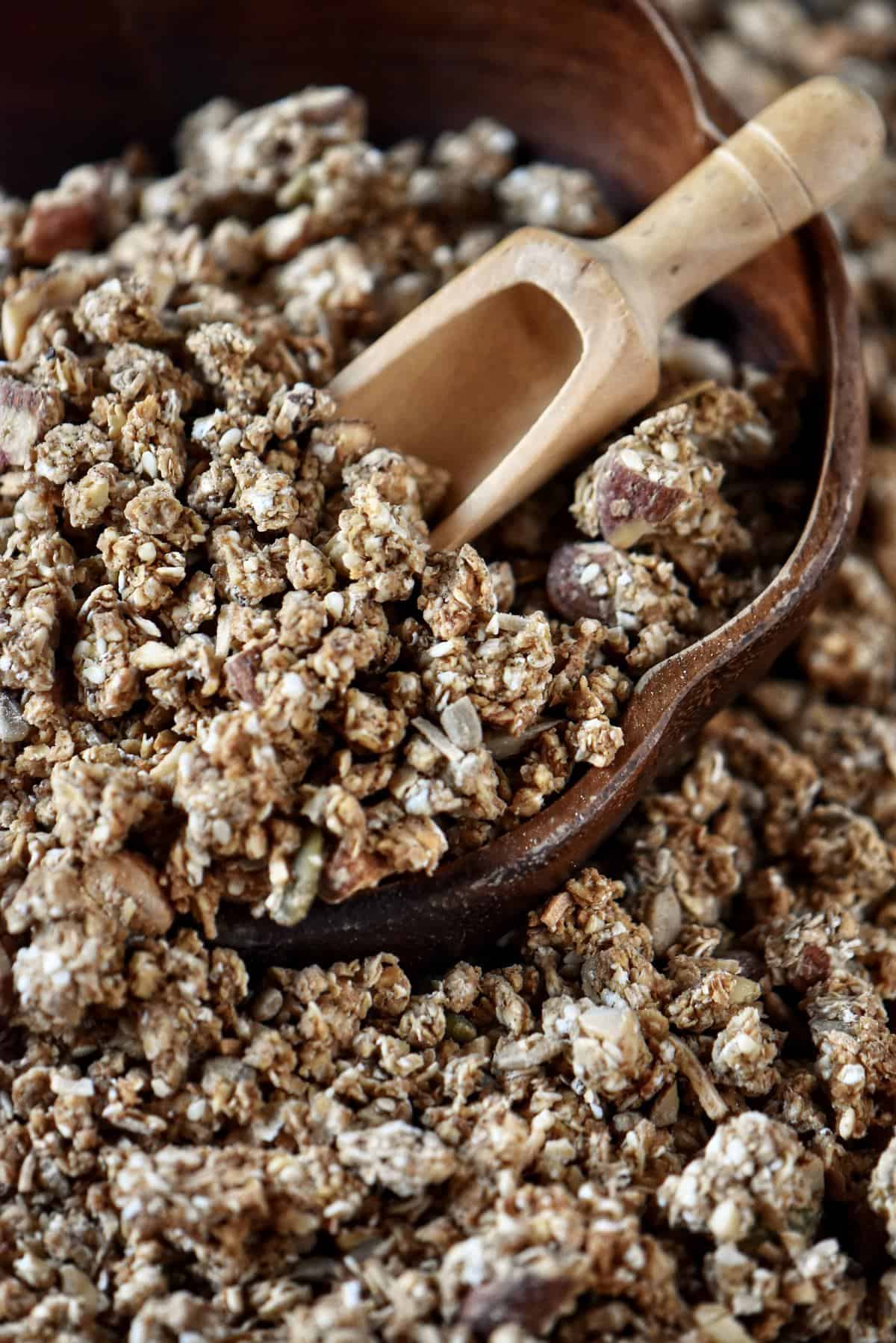 A wooden bowl of clusters of granola.