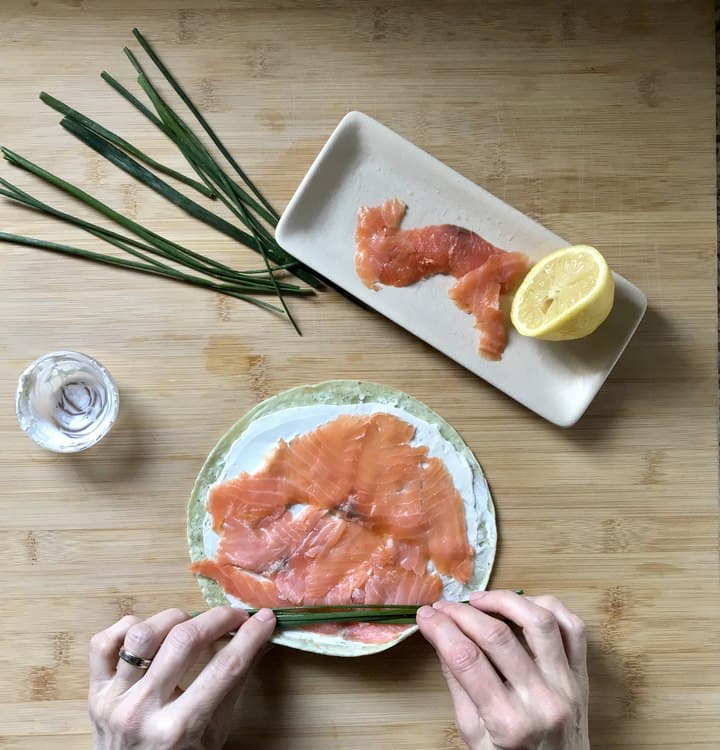 A smoked salmon pinwheel is about to be rolled.