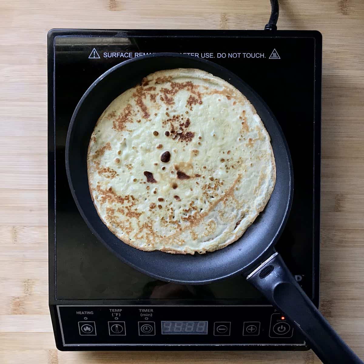 A golden brown crepe in a skillet.