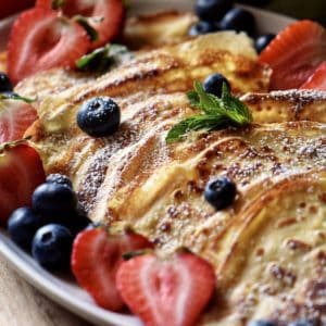 Crepes and berries on a serving platter.