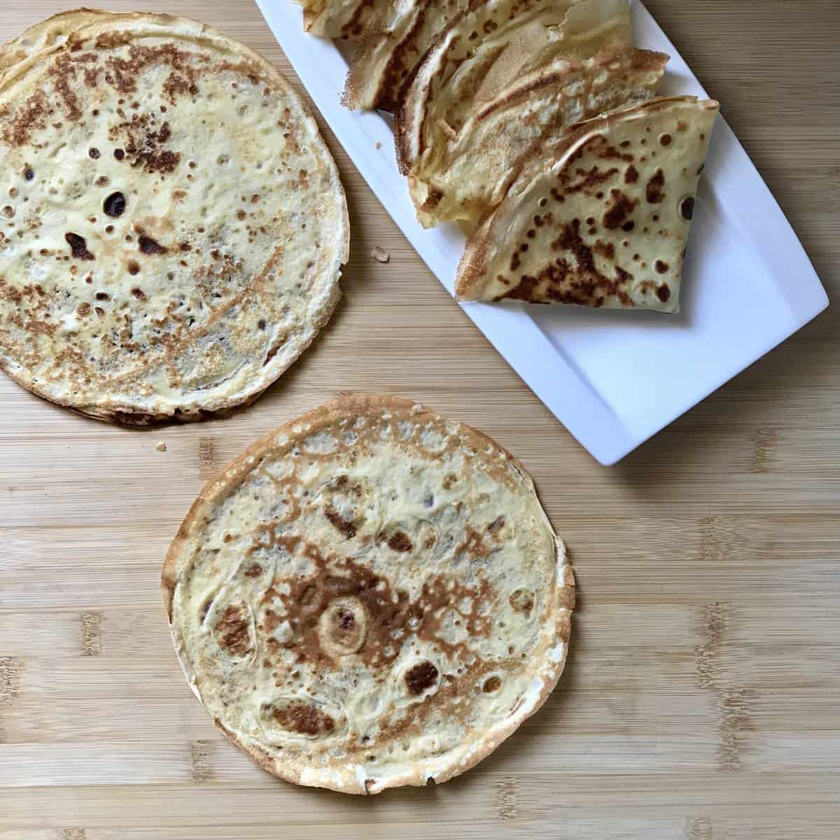 Thin crepes on a wooden board. 