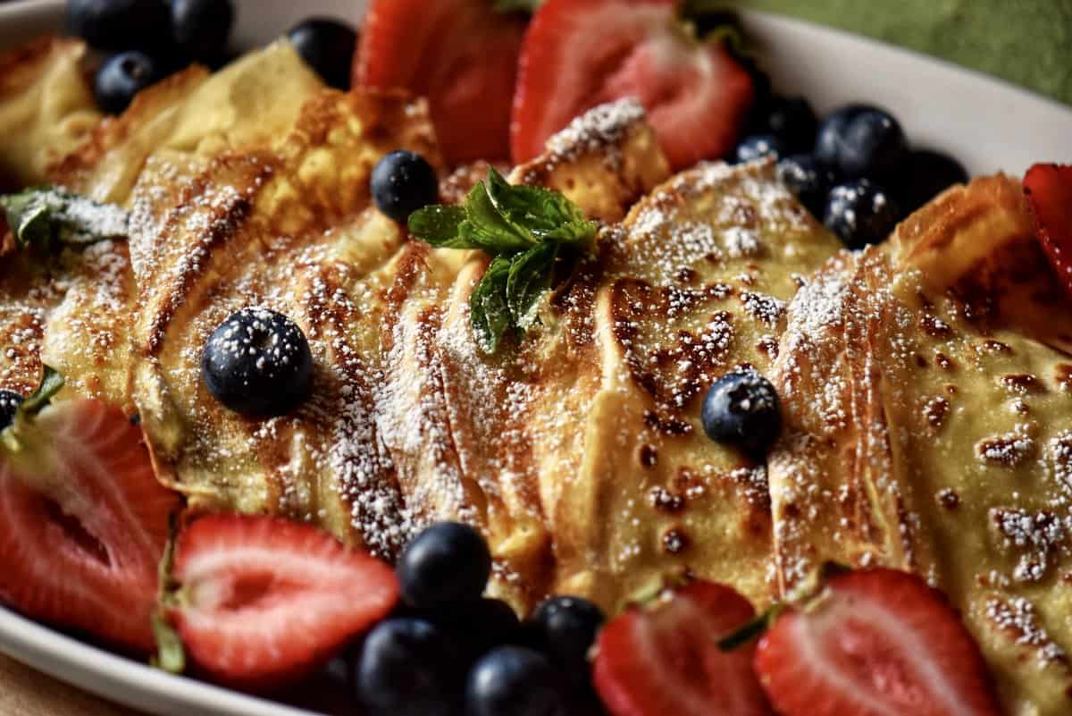Crepes with fresh fruit on a platter.