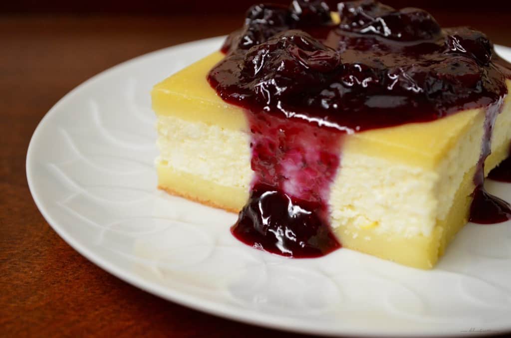 A square piece of cheese blintze topped with blueberry sauce.