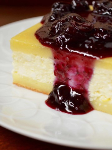 A square piece of cheese blintze topped with blueberry sauce.