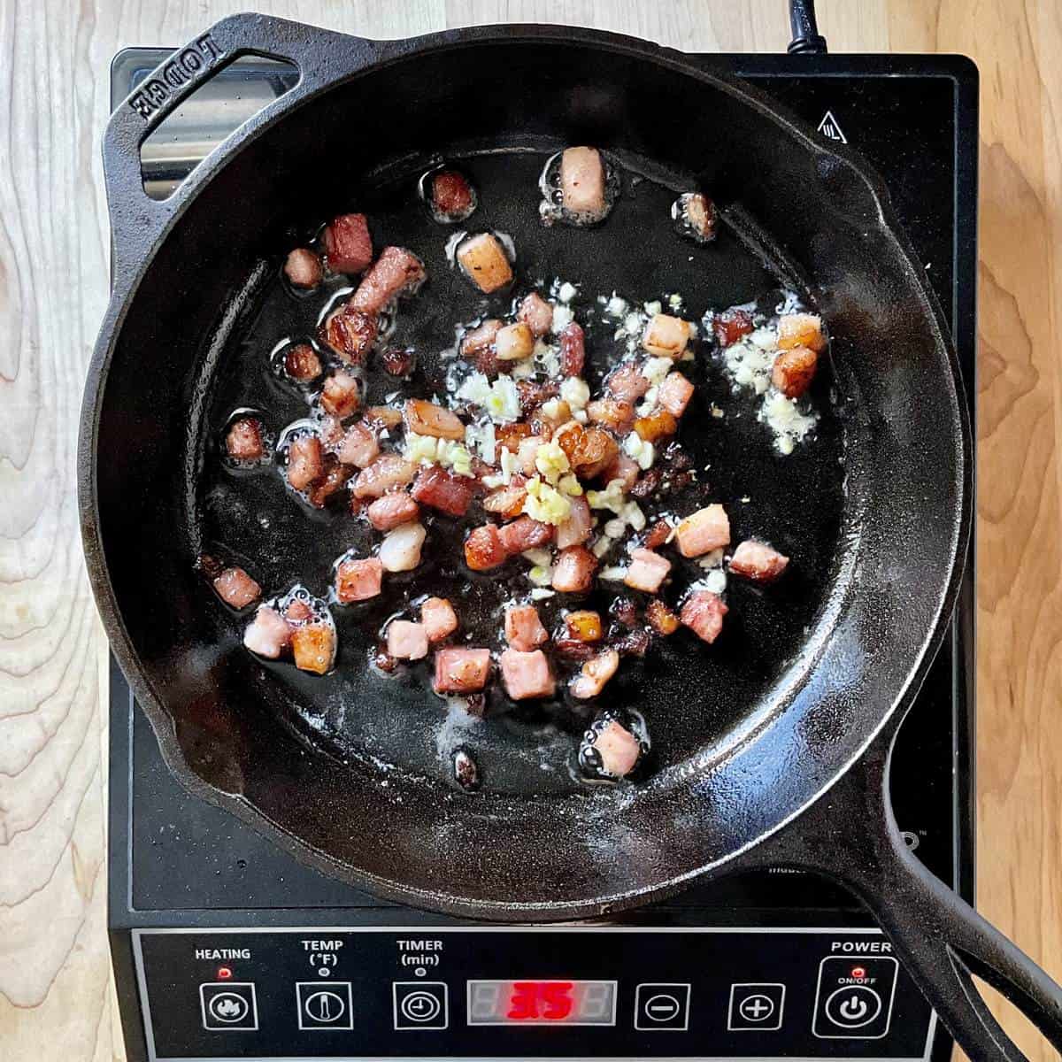 Italian pancetta and garlic sauteed in a cast iron pan.