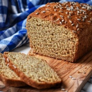 Sliced honey wheat bread on a wooden board.