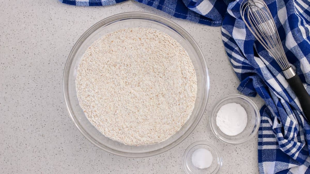 An overhead shot of a bowl of whole wheat flour, salt and baking soda.