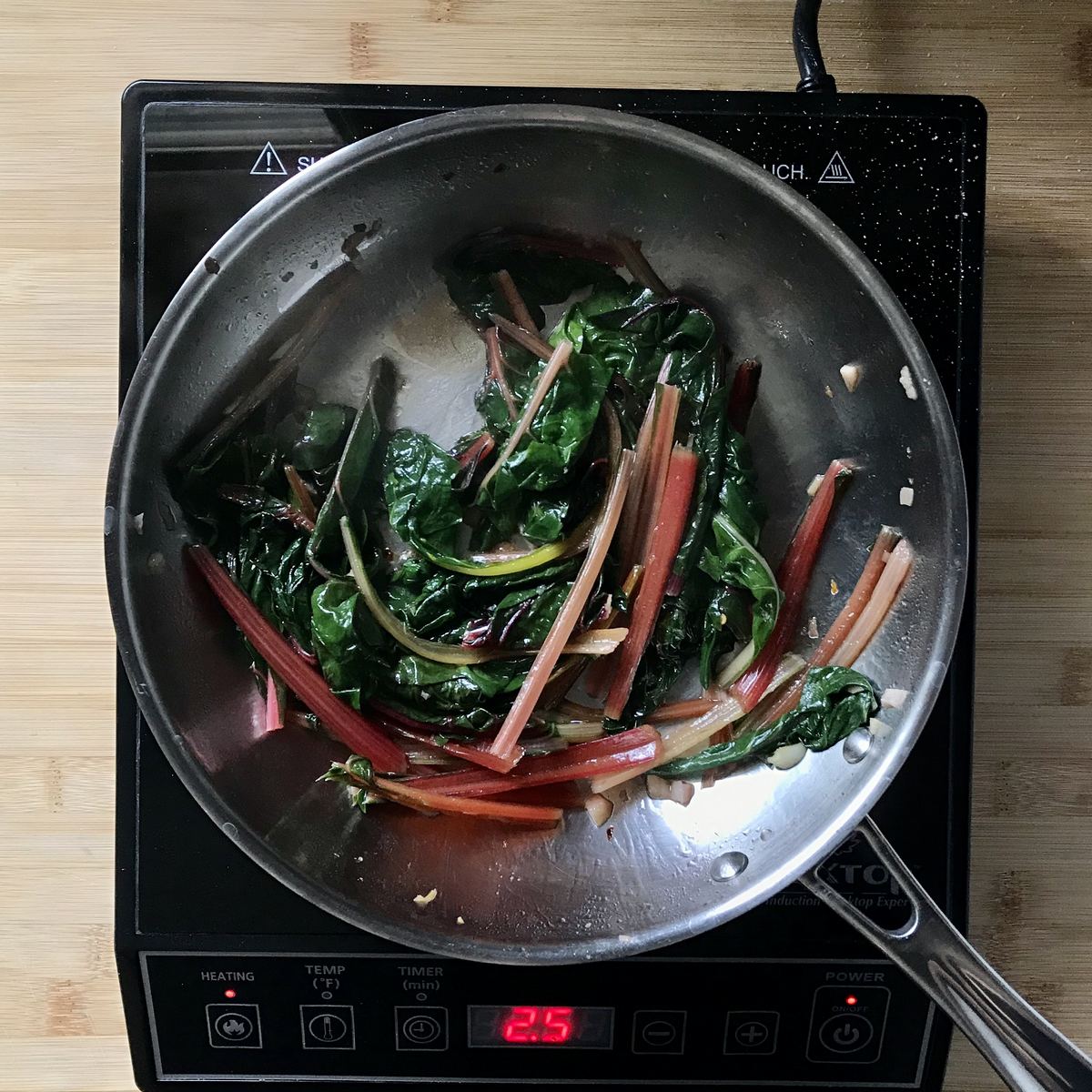 Par-boiled Swiss and rainbow chard added to a pan of sauteed garlic.