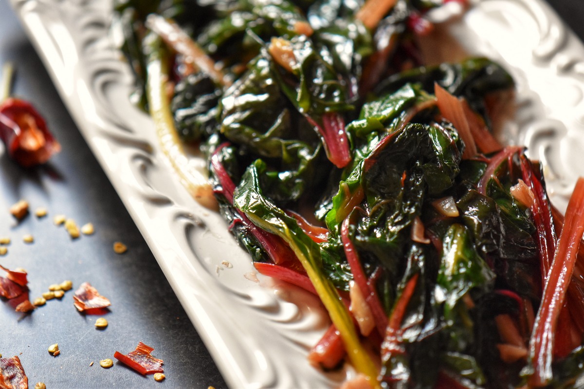 An overhead photo of sauteed Swiss chard in a white serving dish.