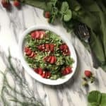 A refreshing salad made with arugula, strawberries and pine nuts.