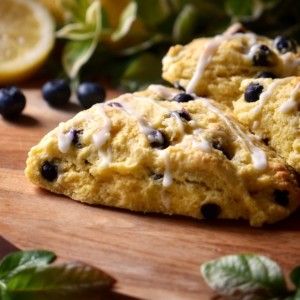 Iced blueberry scones on a wooden surface.