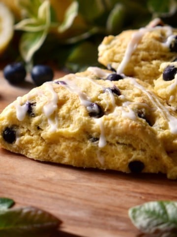 Iced blueberry scones on a wooden surface.
