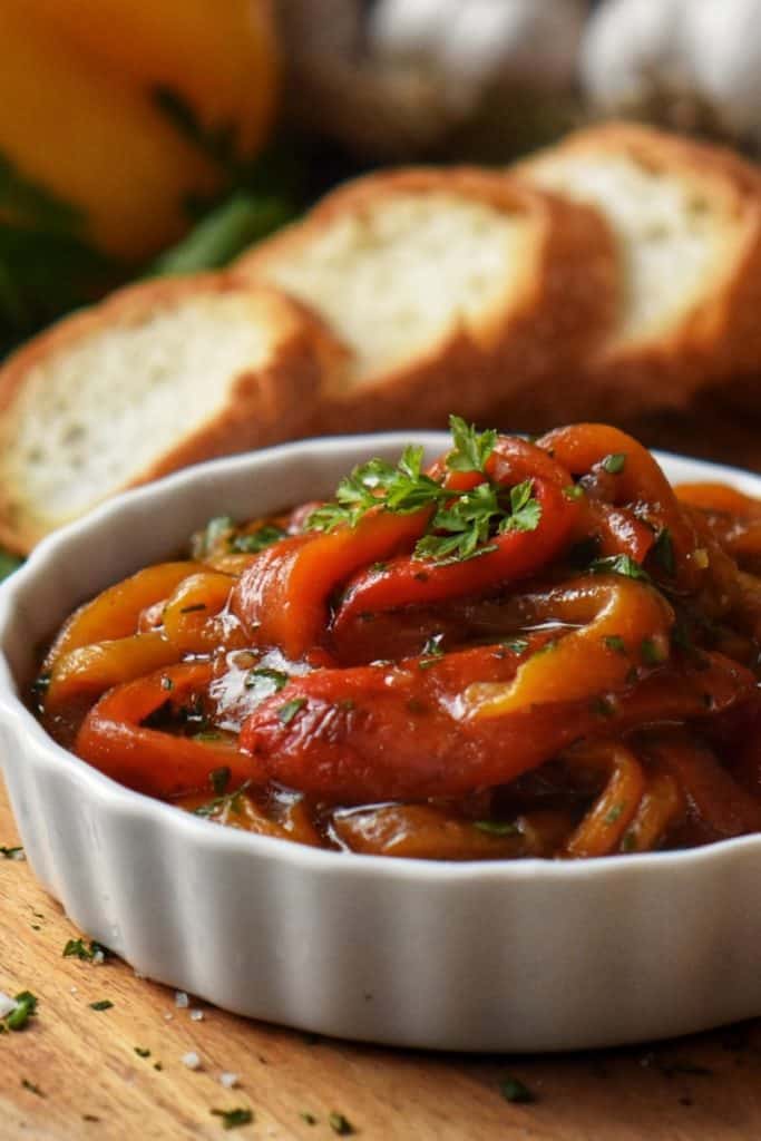 Marinated Roasted Bell Peppers in a white ceramic dish.