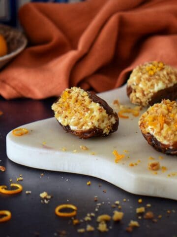 Ricotta and walnut stuffed dates on a marble board.