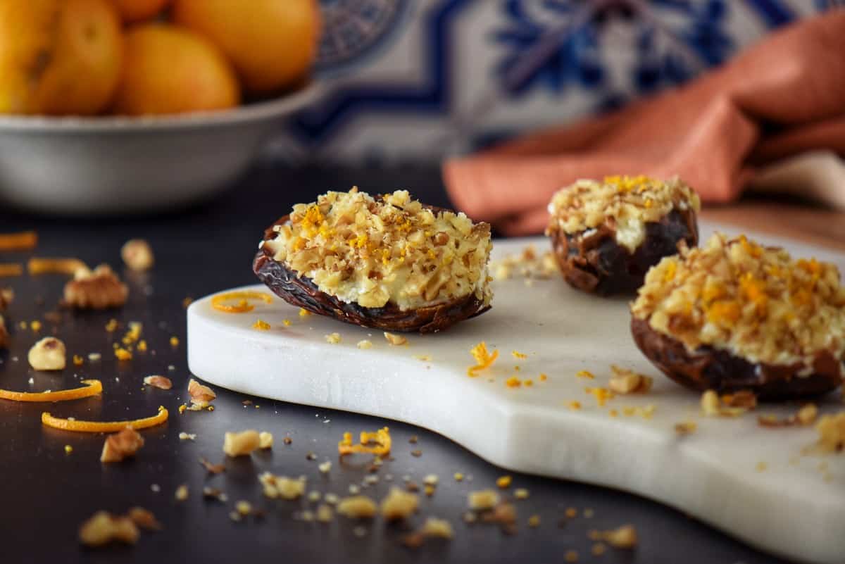 Ricotta stuffed dates garnished with orange zest and finely chopped walnuts.