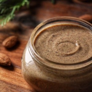 A close up photo of almond butter in a jar.