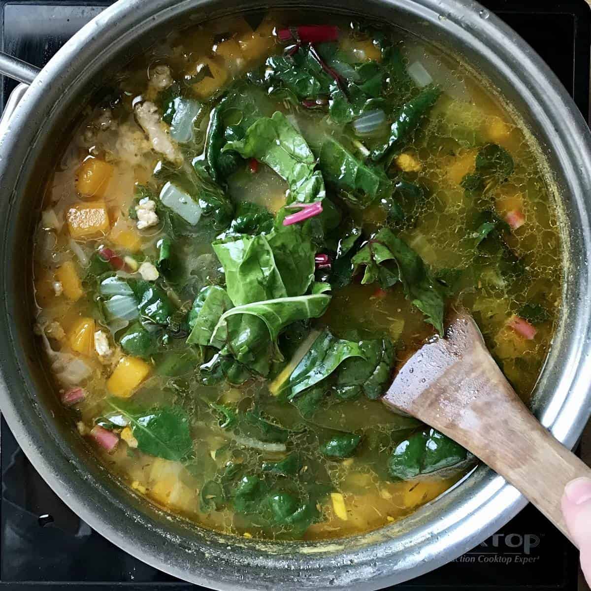 Swiss chard being added to the stockpot. 