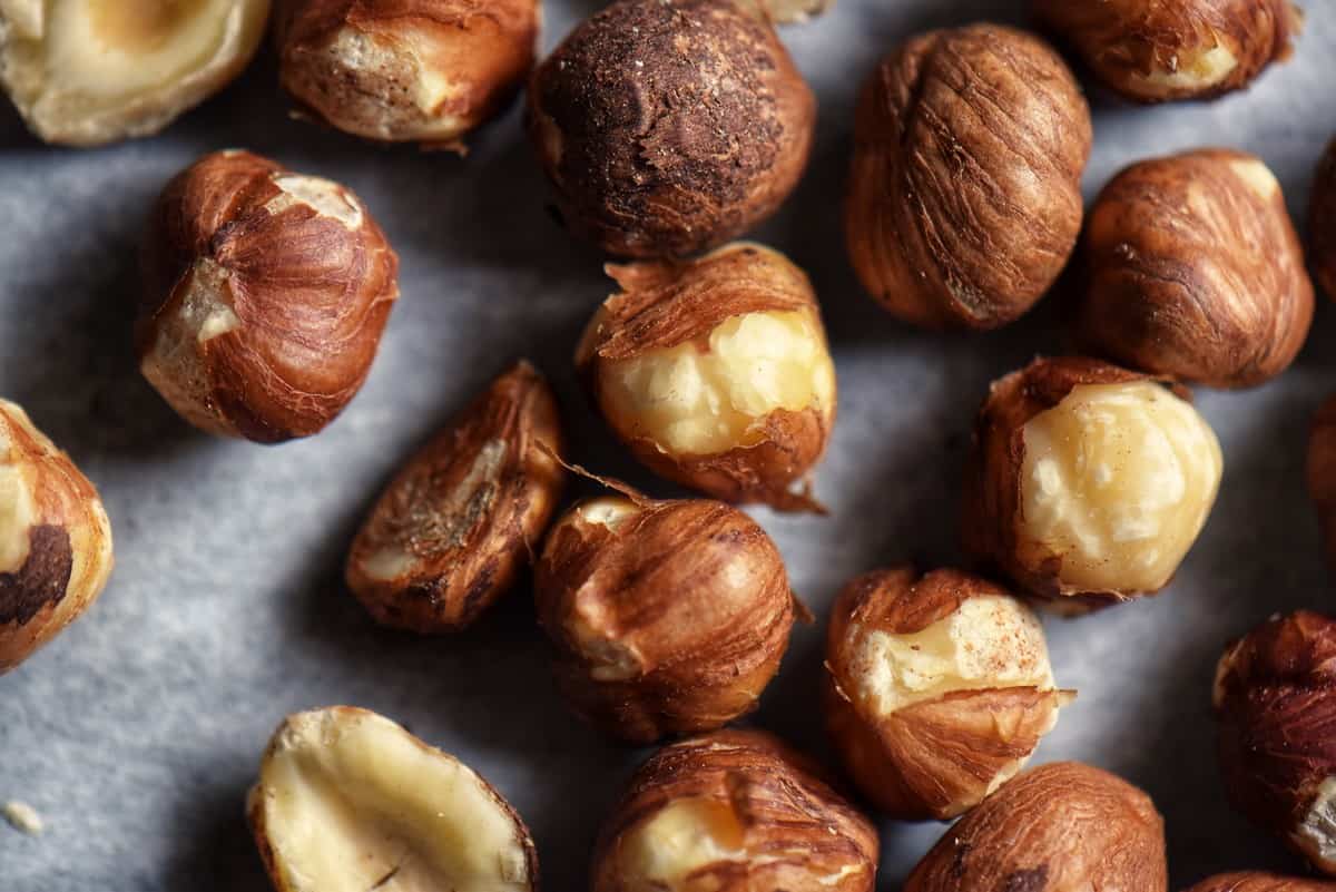 Freshly roasted hazelnuts with some of their skins removed.