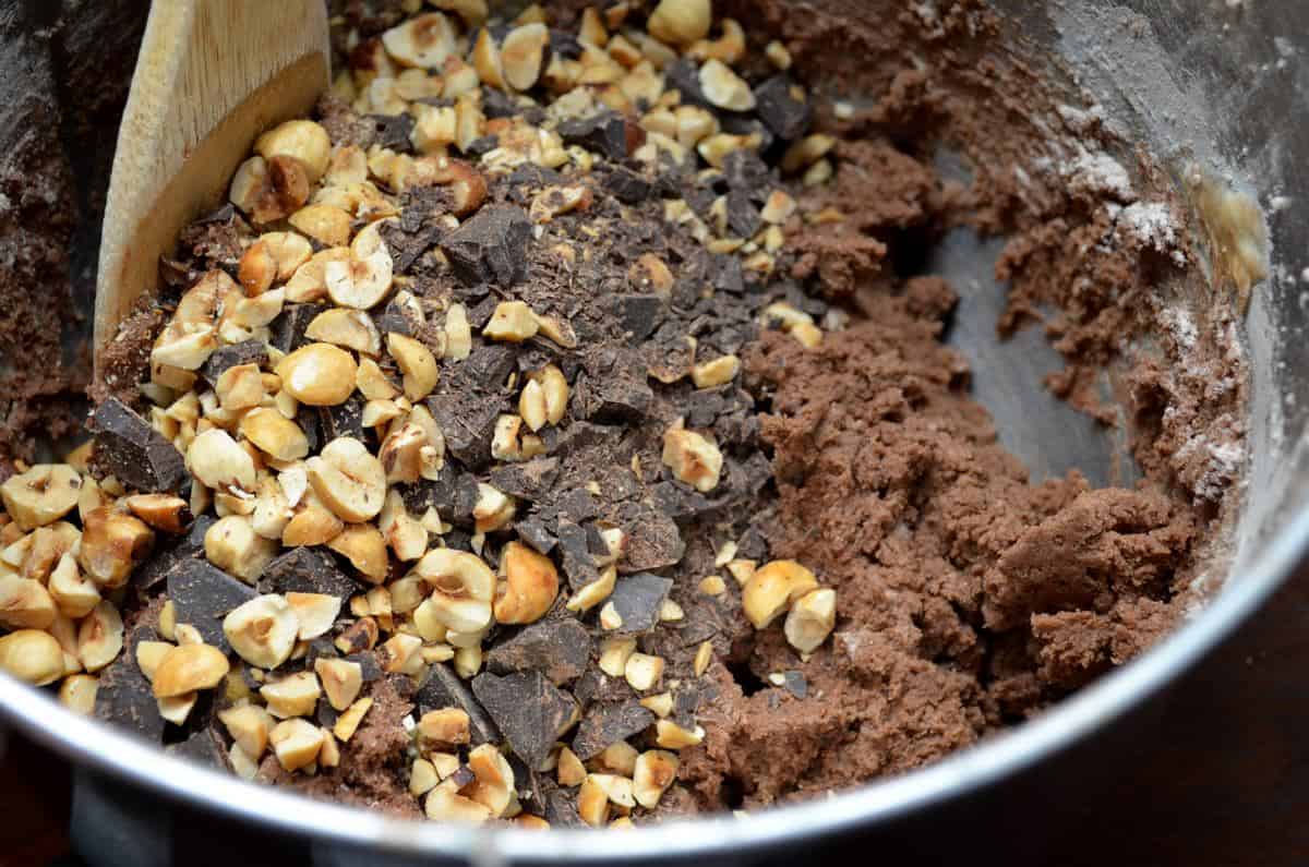 Cocoa, chocolate chunks and hazelnuts are shown as they are combined with the rest of the ingredients to make chocolate biscotti.