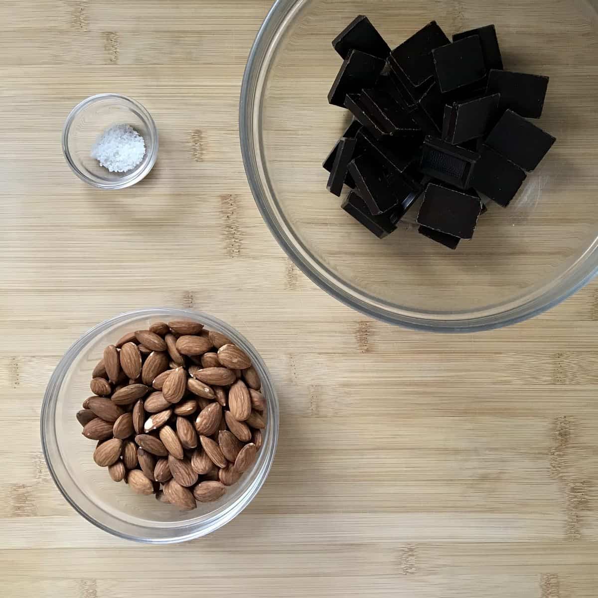 Chocolate, almonds and salt in separate bowls.