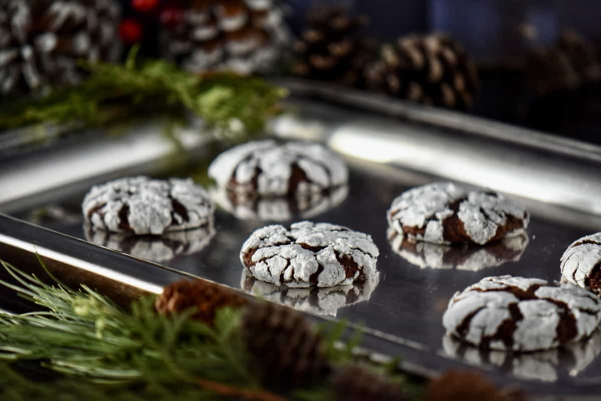Snowcap cookies surrounded by pine cones.
