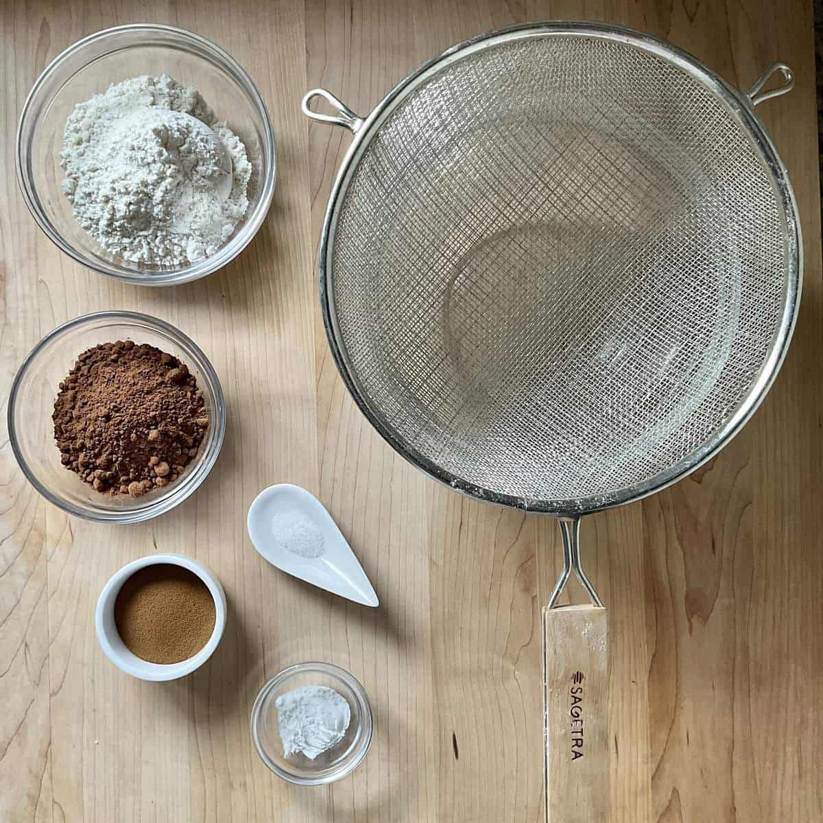 Ingredients to make chocolate crinkle cookies on a wooden board.